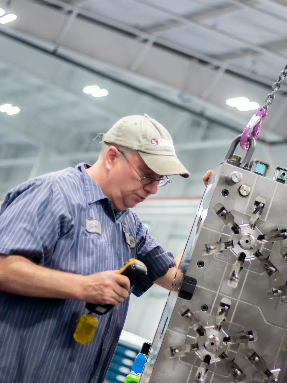factory worker inspects injection mold