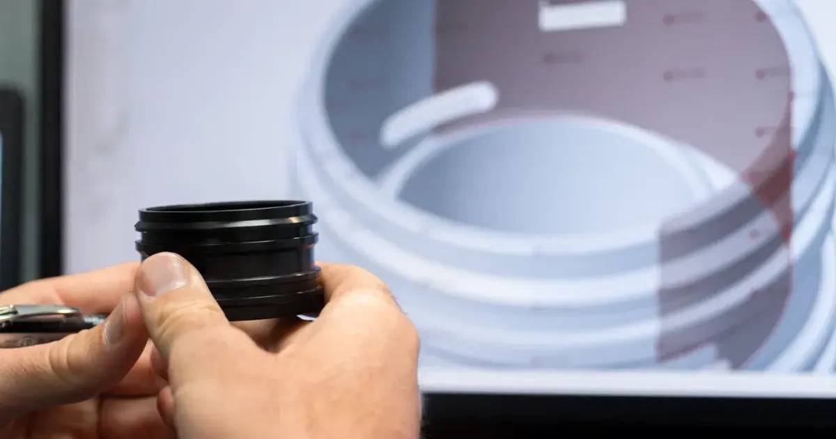 hands holding machined part with cad model