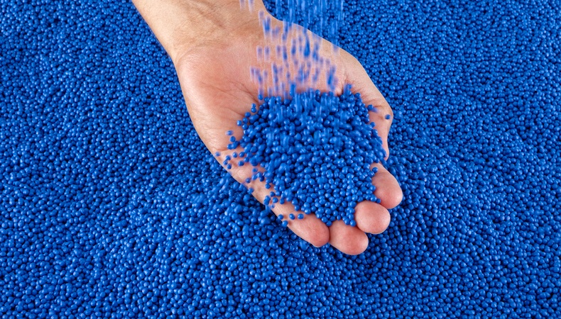 blue-plastic-pellets-falling-into-open-hand